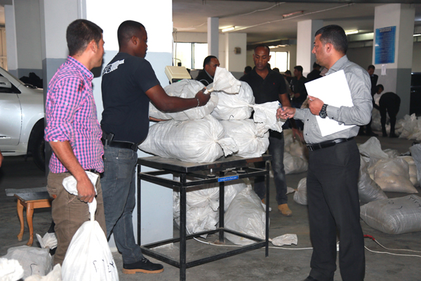 Anti-Narcotics Department personnel collect illegal drugs seized in 71 cases, which were destroyed on Wednesday (Photo courtesy of PSD)